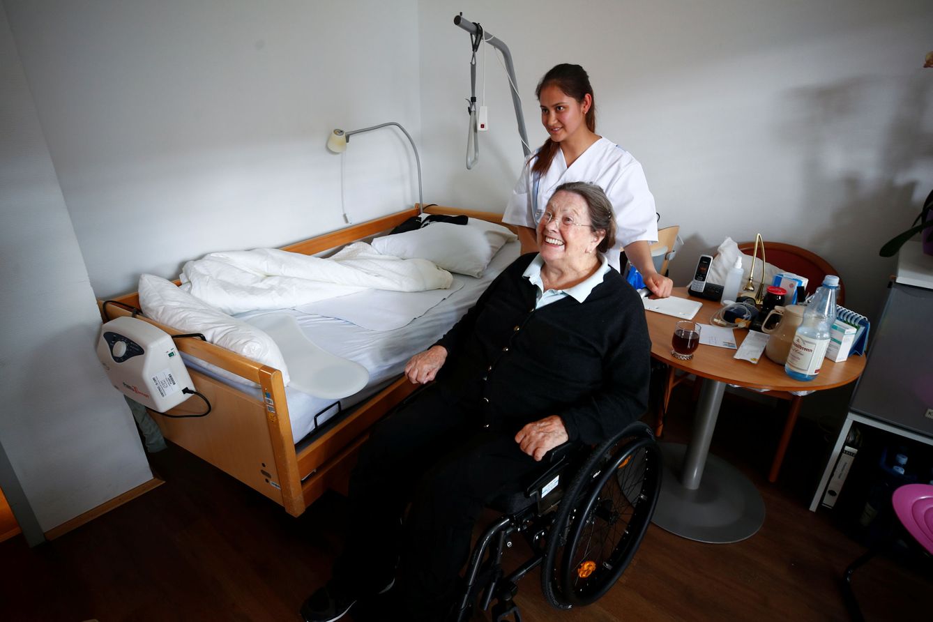 La anciana Elisabeth Grohmann es ayudada por la refugiada afgana Elahi Temori en Düsseldorf, en septiembre de 2018. (Reuters)