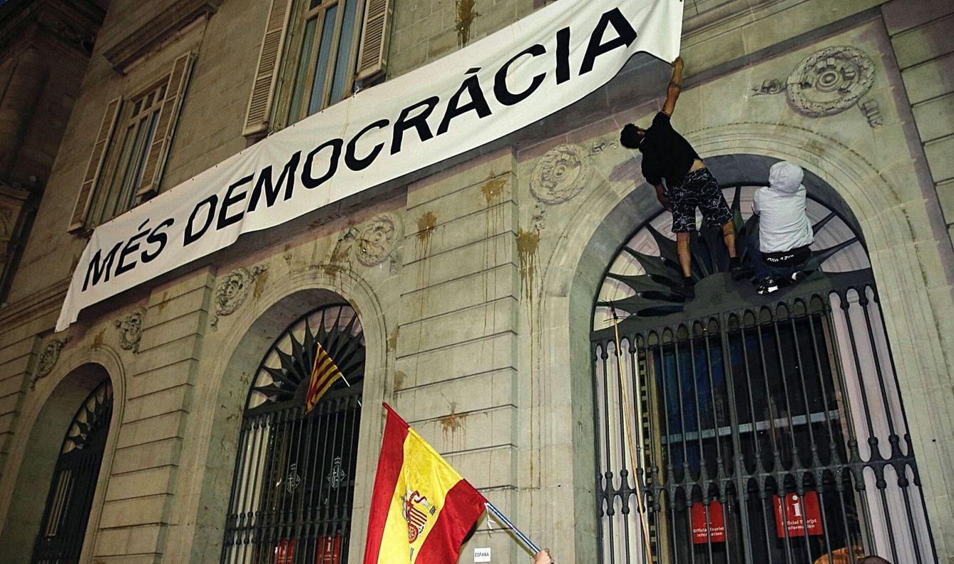  Dos personas intentan arrancar la pancarta colgada en el Ayuntamiento de Barcelona. (EFE)