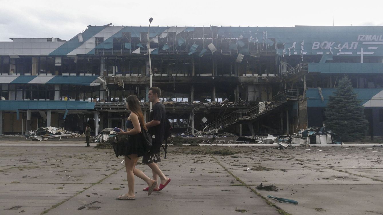 Foto: Dos personas caminan cerca de una zona bombardeada en Izmail, en la región de Odesa. (EFE/Igor Tkachenko)