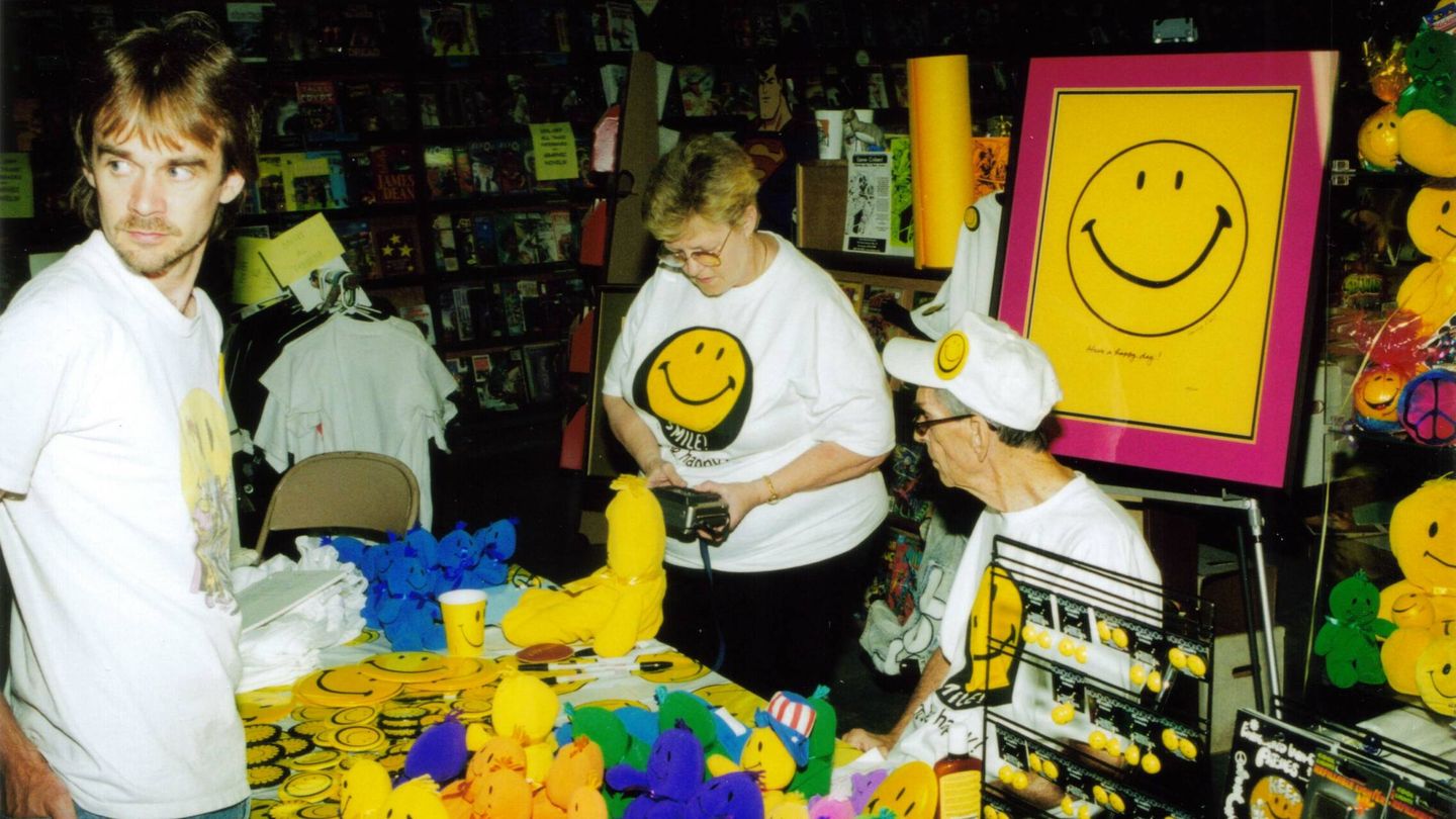 Ball (sentado) en una firma de productos con su logotipo de Smiley en 1998. (Wikimedia)