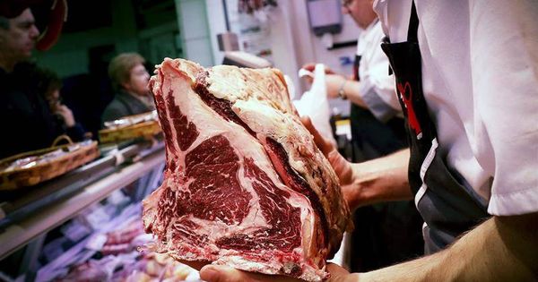 Foto:  Un carnicero se dispone a cortar unos chuletones en un puesto de uno de los mercados de Pamplona que han visto incrementada su actividad para preparar la última cena de 2017 (Villar López / EFE)