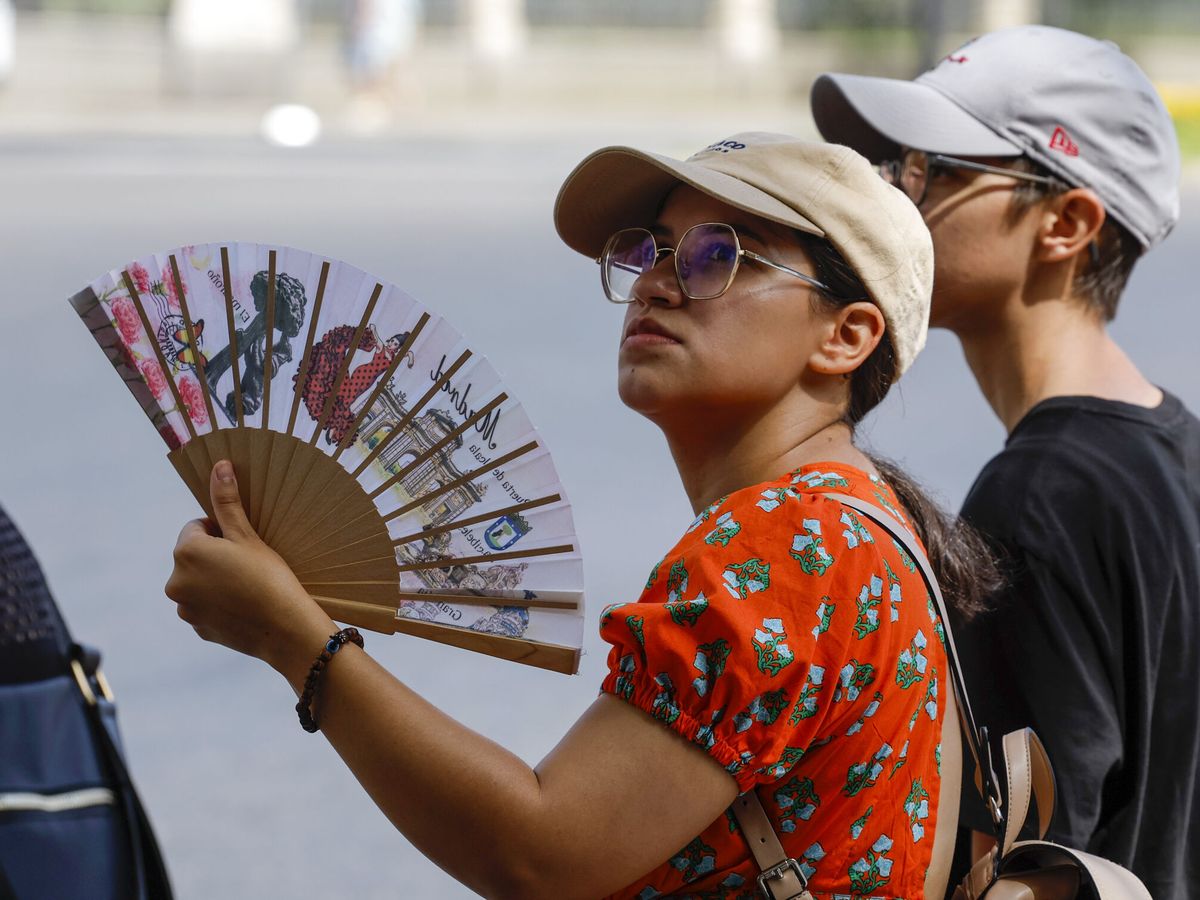 Foto: Una mujer se abanica para combatir el intenso calor de esta semana. (EFE/Chema Moya)