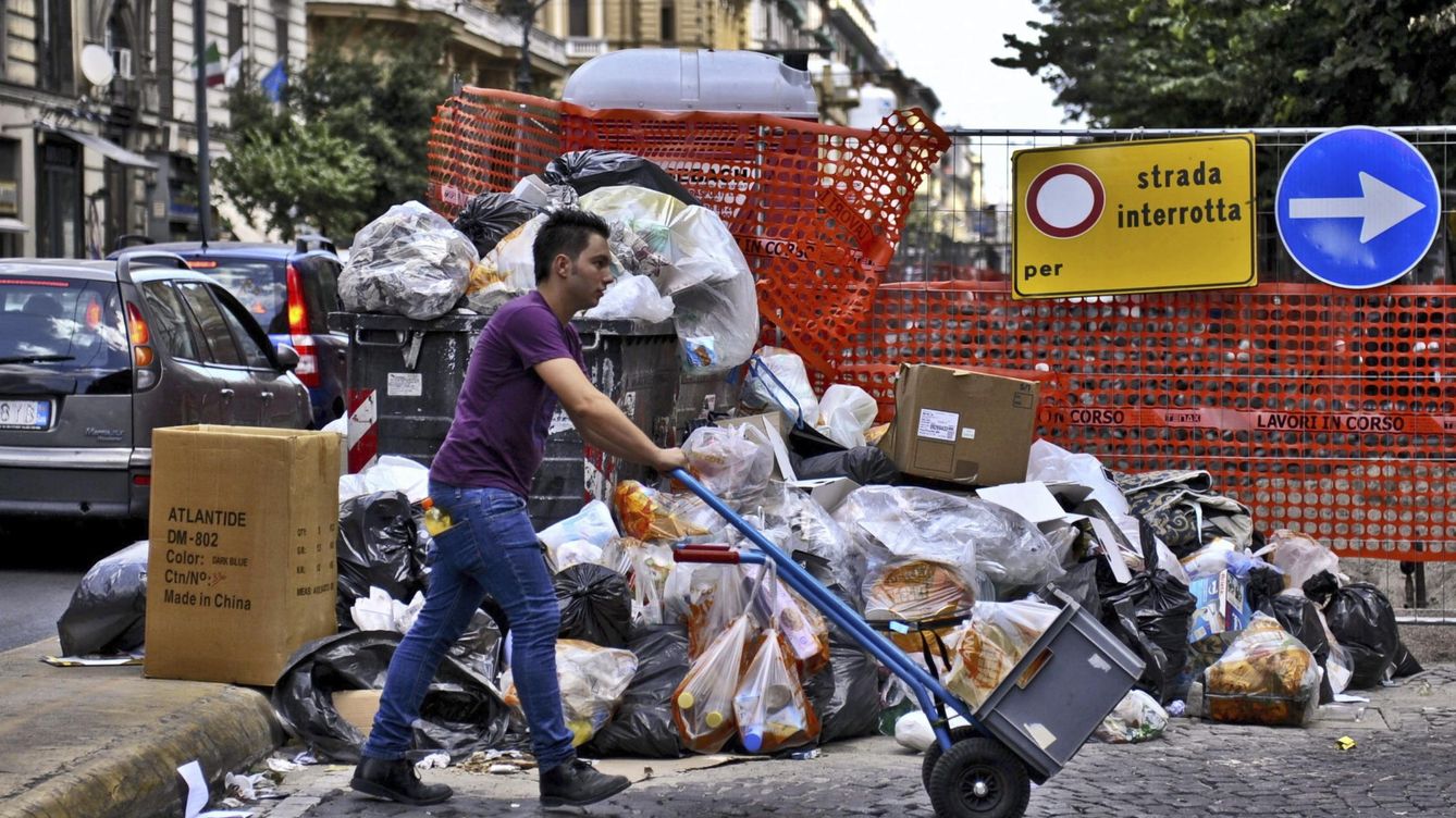 Foto: Un hombre pasa por delante de un montón de basura apilada en una calle de Nápoles. (EFE)