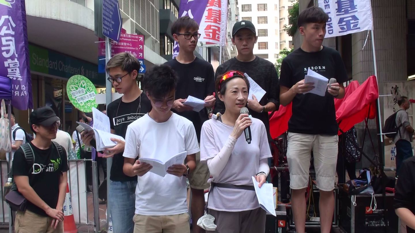 La diputada Tanya Chan, del Partido Cívico, una de las procesadas estos días, en un acto junto al grupo prodemocracia Boyz Reborn, una de cuyas canciones se convirtió en himno durante la Revolución de los Paraguas, el 1 de julio de 2018. (A. García)