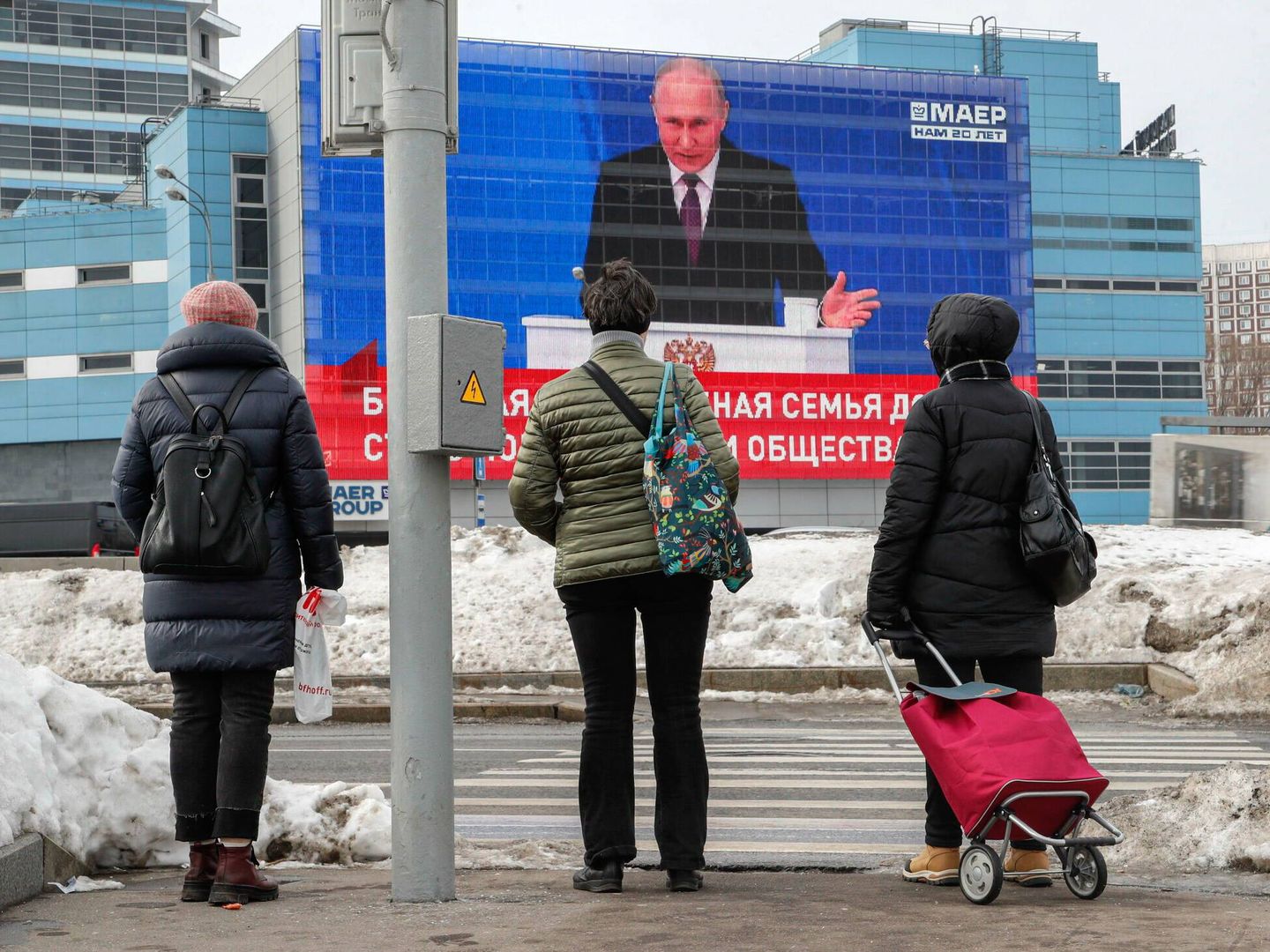 Varios peatones observan a Putin en una pantalla de una calle de Moscú el pasado febrero. (EFE/Maxim Shipenkov)