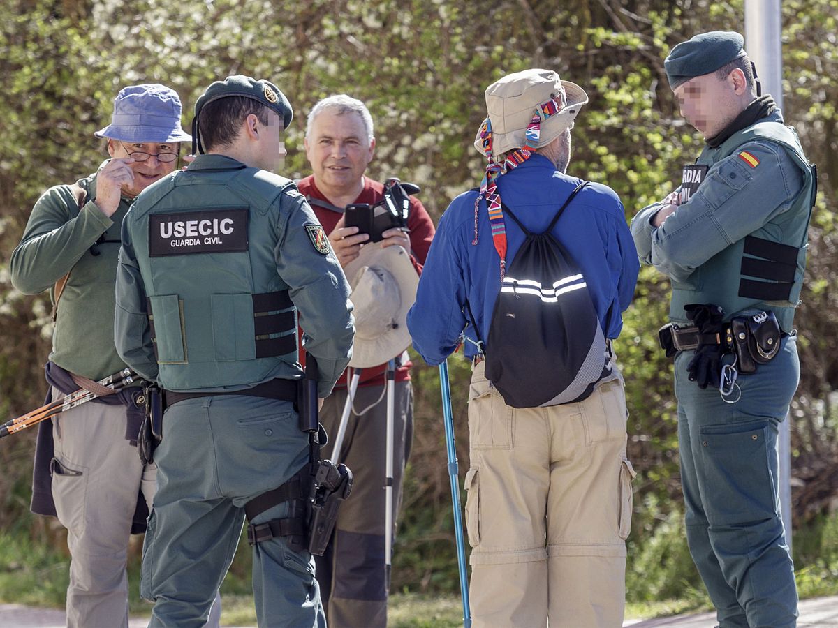 Foto: Agentes de la Guardia Civil hablan con unos peregrinos en una imagen de archivo. (EFE/Santi Otero)