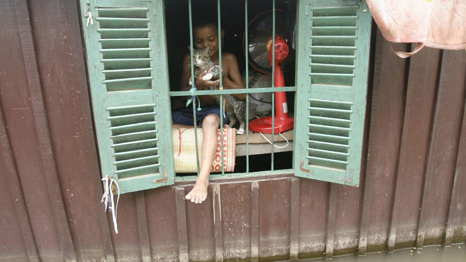 Foto: Un niño se asoma a la ventana de su casa en un pueblo situado en Camboya. (Efe)