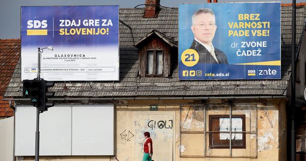 Foto: Una mujer pasa por delante de dos carteles electorales del Partido Democrático en Liubliana, el 31 de mayo de 2018. (Reuters)