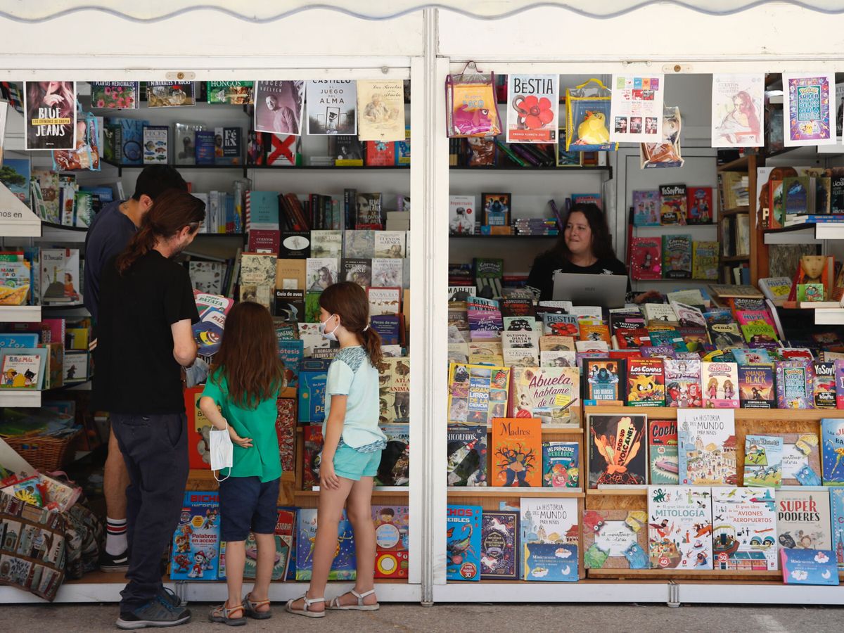 Foto: Dos niñas eligen libros en una de las casetas de la Feria del Libro de Madrid. (EFE/Javier López)