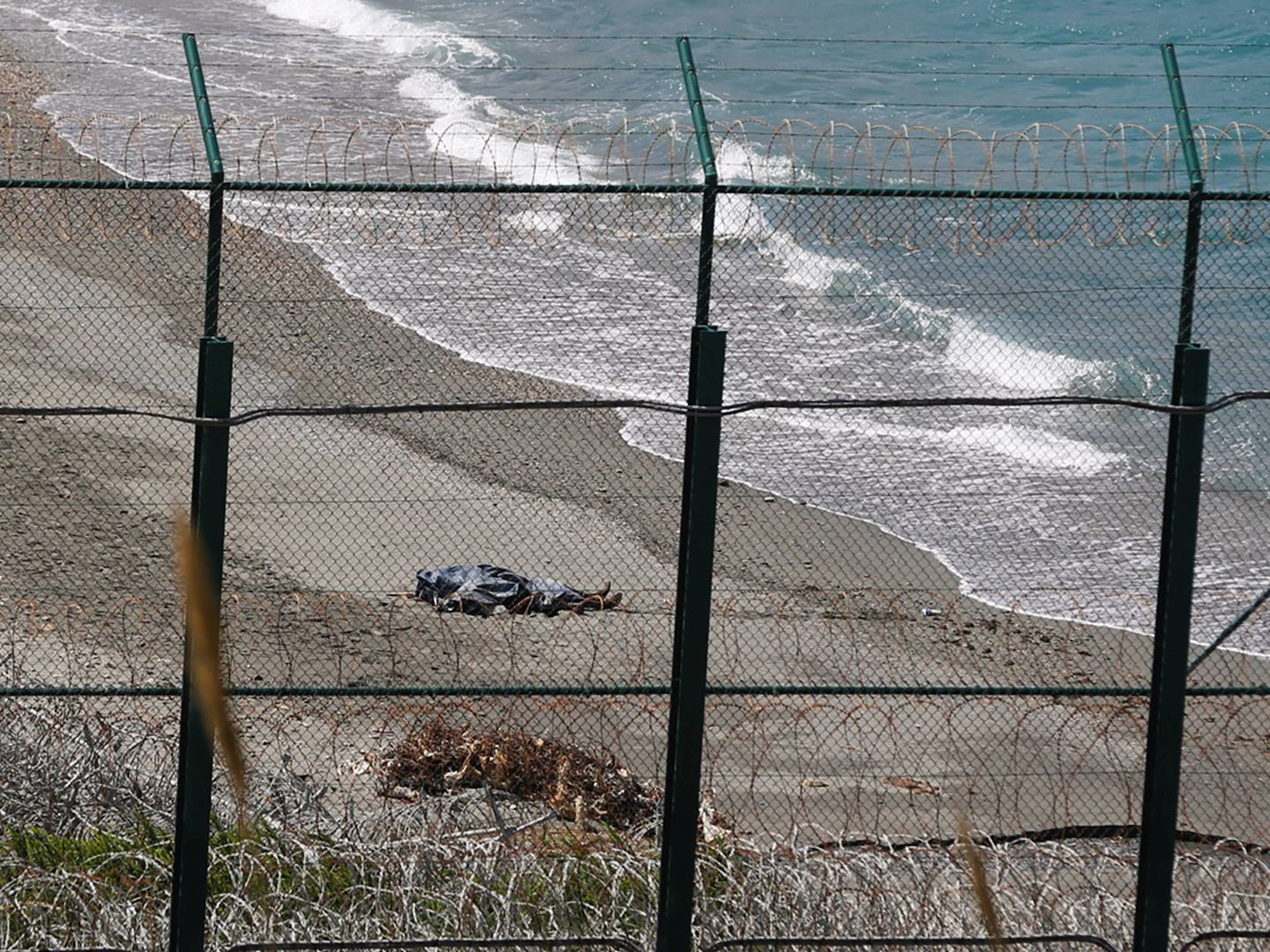El cadáver de un migrante que intentó llegar a Ceuta, en la playa marroquí de Belyounech. (Reuters) 