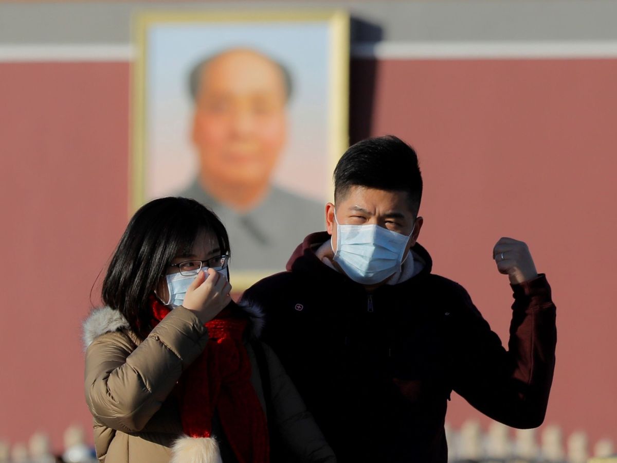 Foto: Una pareja camina por el centro de Pekín con mascarillas. (EFE)