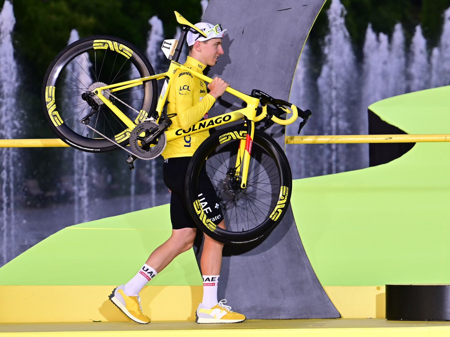 Pogacar sube con su bicicleta al podio de ganadores tras vencer en la última etapa del Tour. (EFE/Papon Bernard)