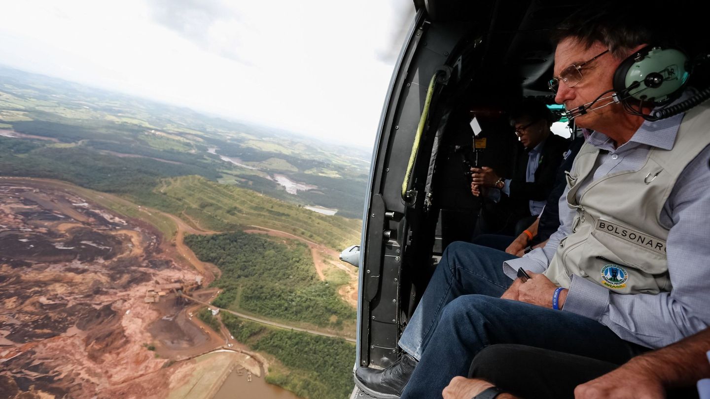 Fotografía cedida por la Presidencia de Brasil que muestra al presidente Jair Bolsonaro mientras sobrevuela la zona afectada por una avalancha en Brumadin. (EFE)