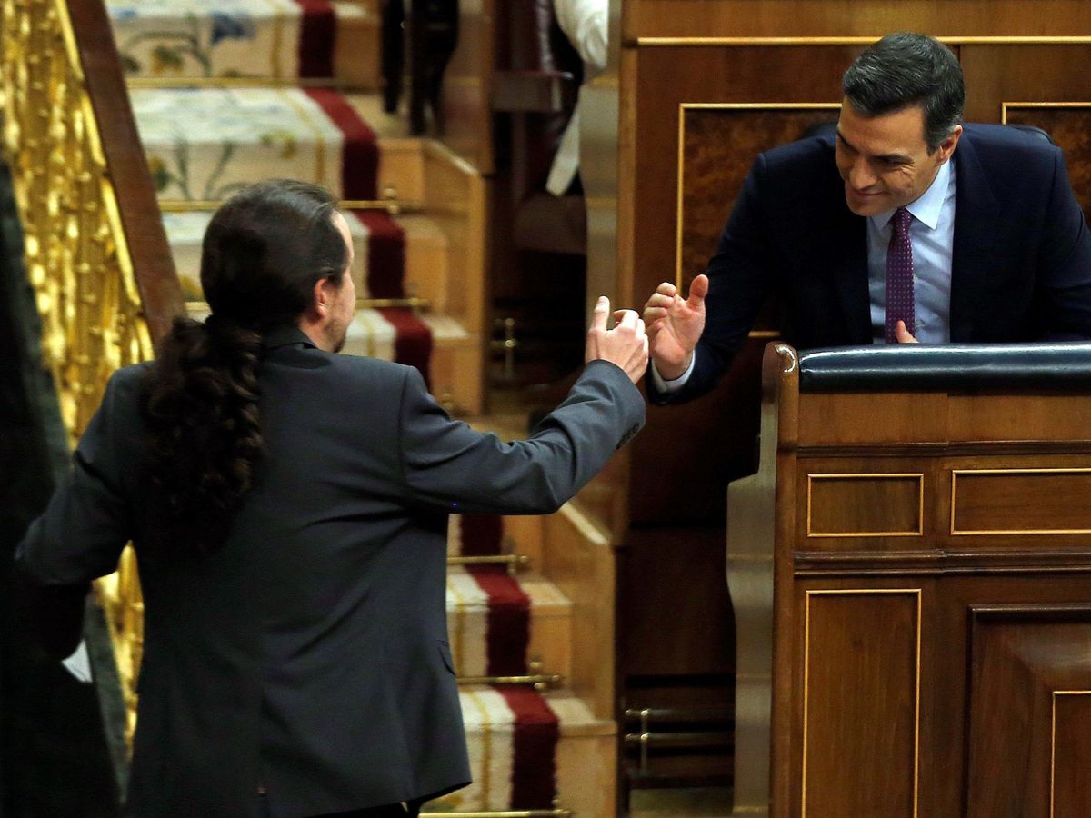 Foto: Pedro Sánchez y Pablo Iglesias estrechan sus manos tras la intervención del líder de Unidas Podemos en el debate de investidura en el Congreso, este 4 de enero. (EFE)
