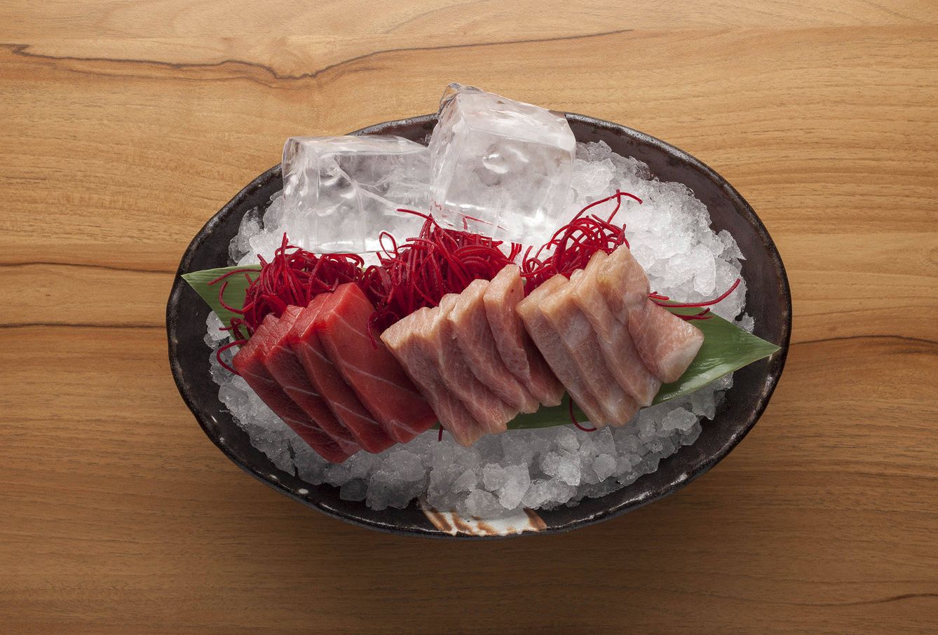 El sashimi, servido sobre gruesos cubos de hielo (siguiendo la tradición japonesa)