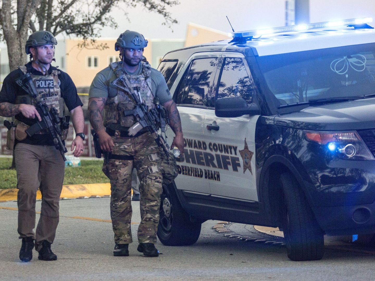 Dos miembros del equipo SWAT montan guardia frente a la entrada lateral tras el tiroteo. (EFE)