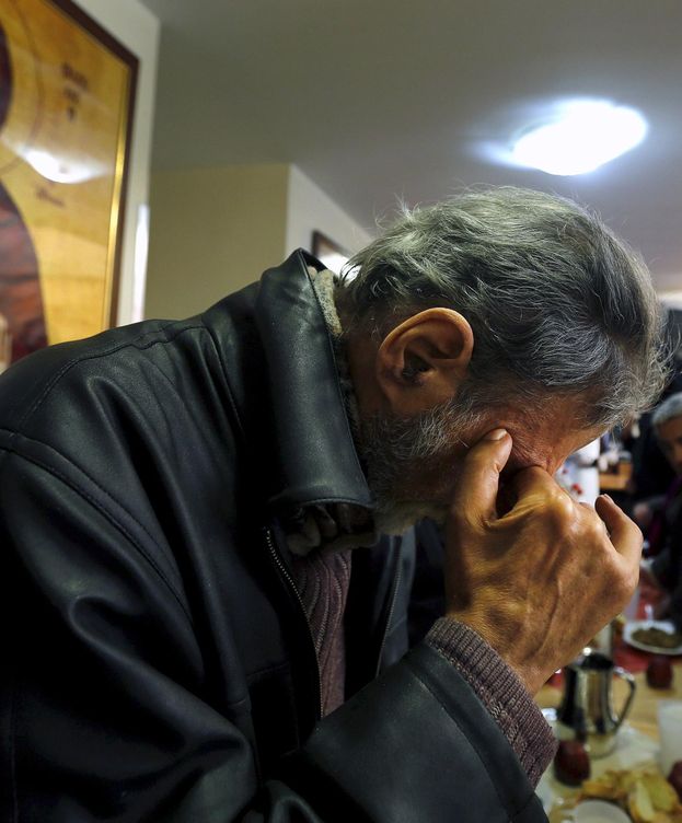 Foto: Un griego reza en una iglesia ortodoxa mientras espera su ración de comida gratis. (Efe)