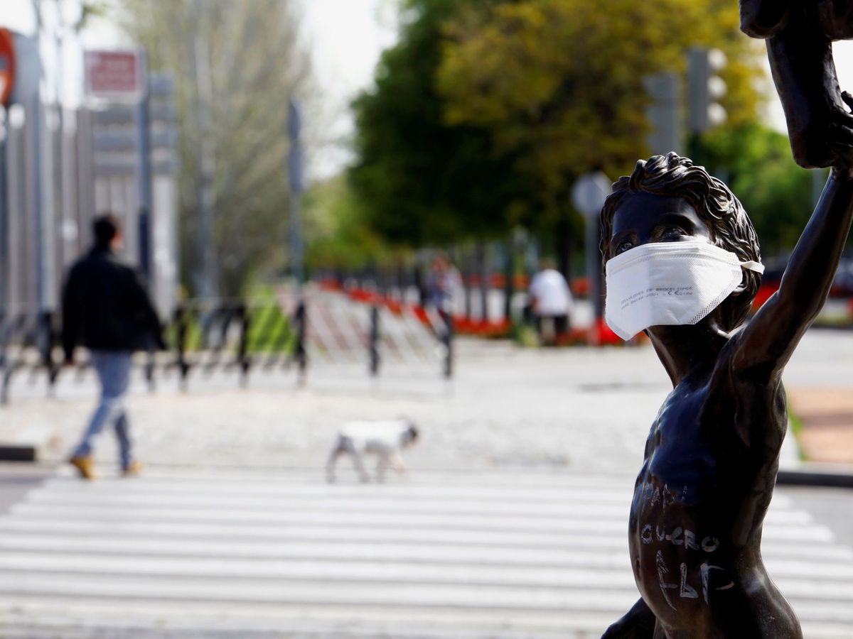 Foto: Una escultura de un niño protegida con una mascarilla en Córdoba (EFE)
