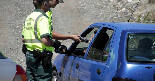 Foto: Un conductor, sometido a una prueba por varios guardias civiles. (EFE)