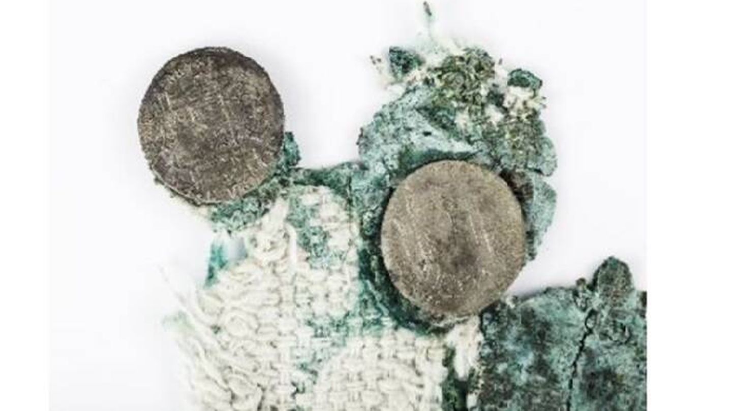 Ejemplo de monedas adheridas a los restos de la saca de algodón. (Cultura)