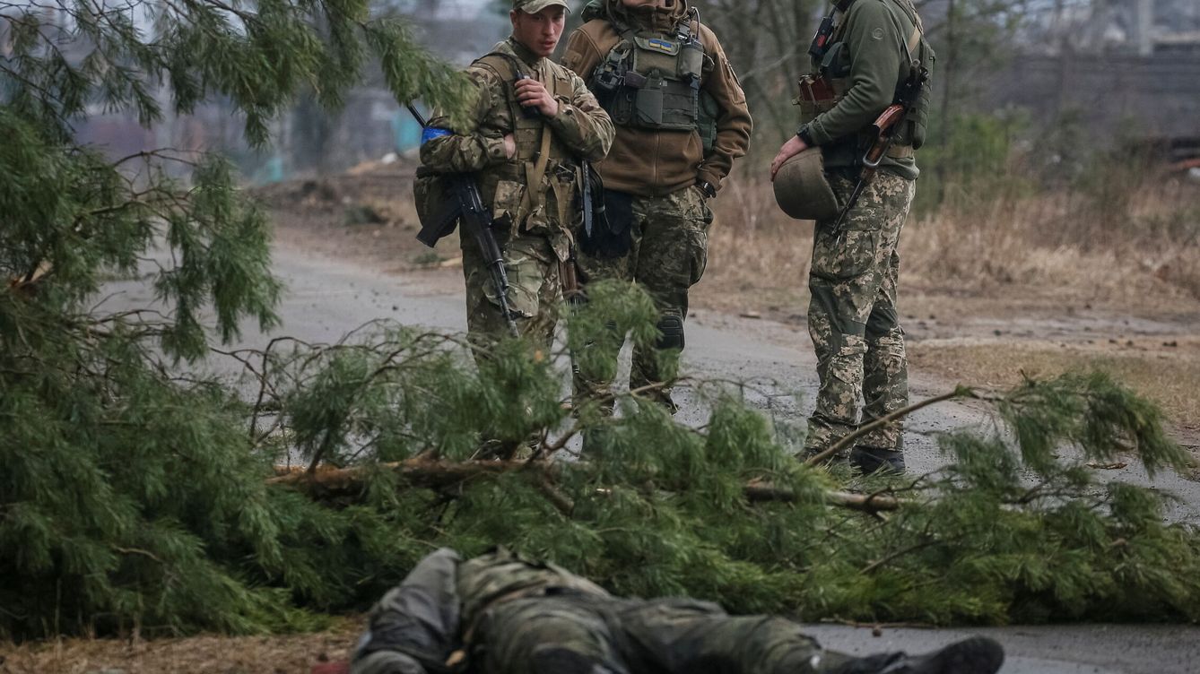 Foto: Miembros del servicio ucraniano junto al cuerpo de un soldado ruso en la línea del frente cerca de Kiev. (Reuters/Gleb Garanich)