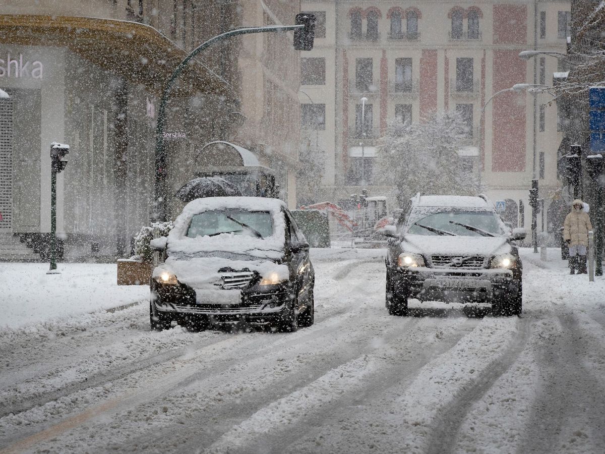 Foto: Foto de archivo de dos coches circulando bajo una intensa nevada en Pamplona. (EFE)