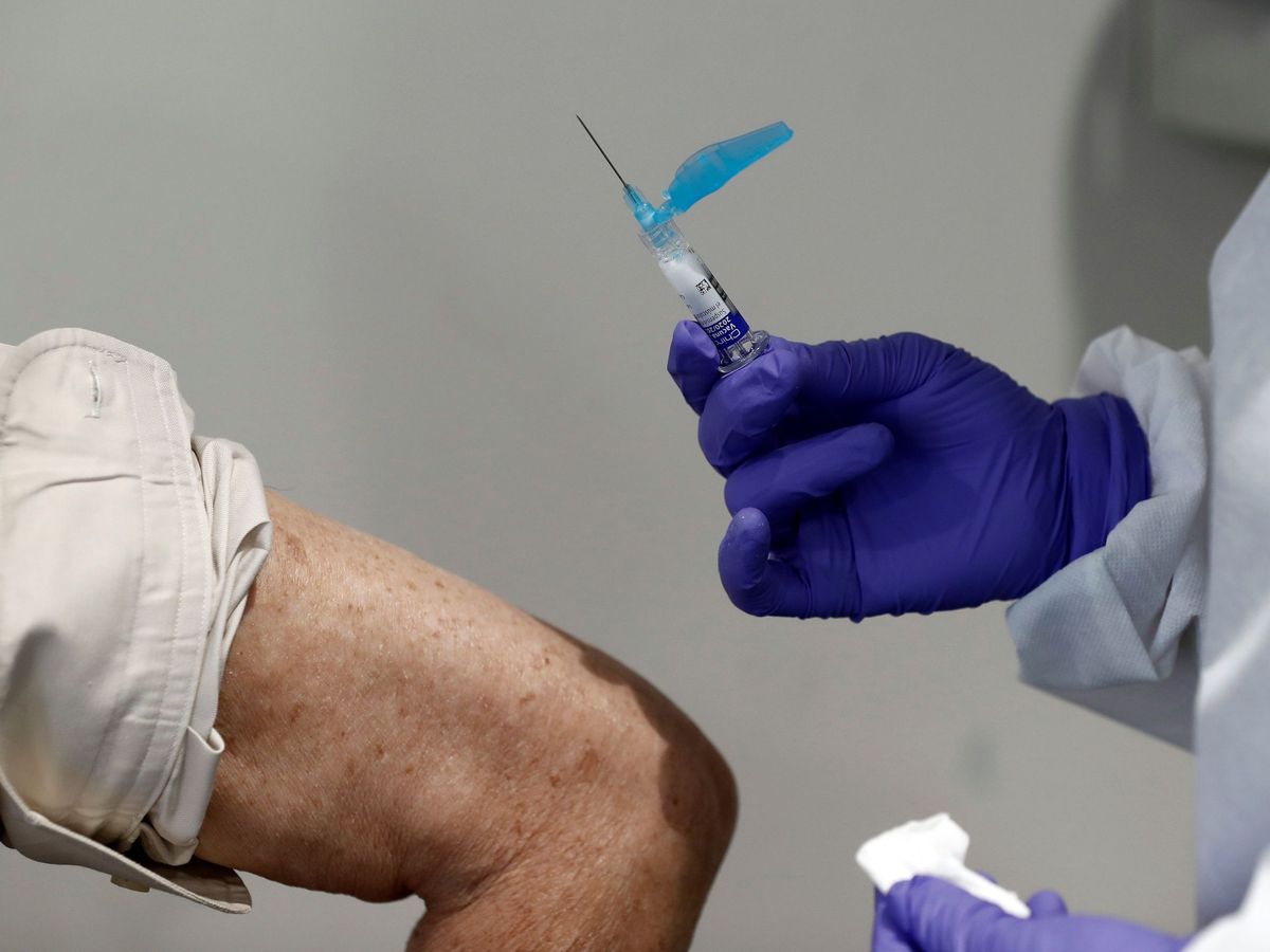 Foto: Un trabajador sanitario se prepara para poner la vacuna contra la gripe a un paciente. (EFE)