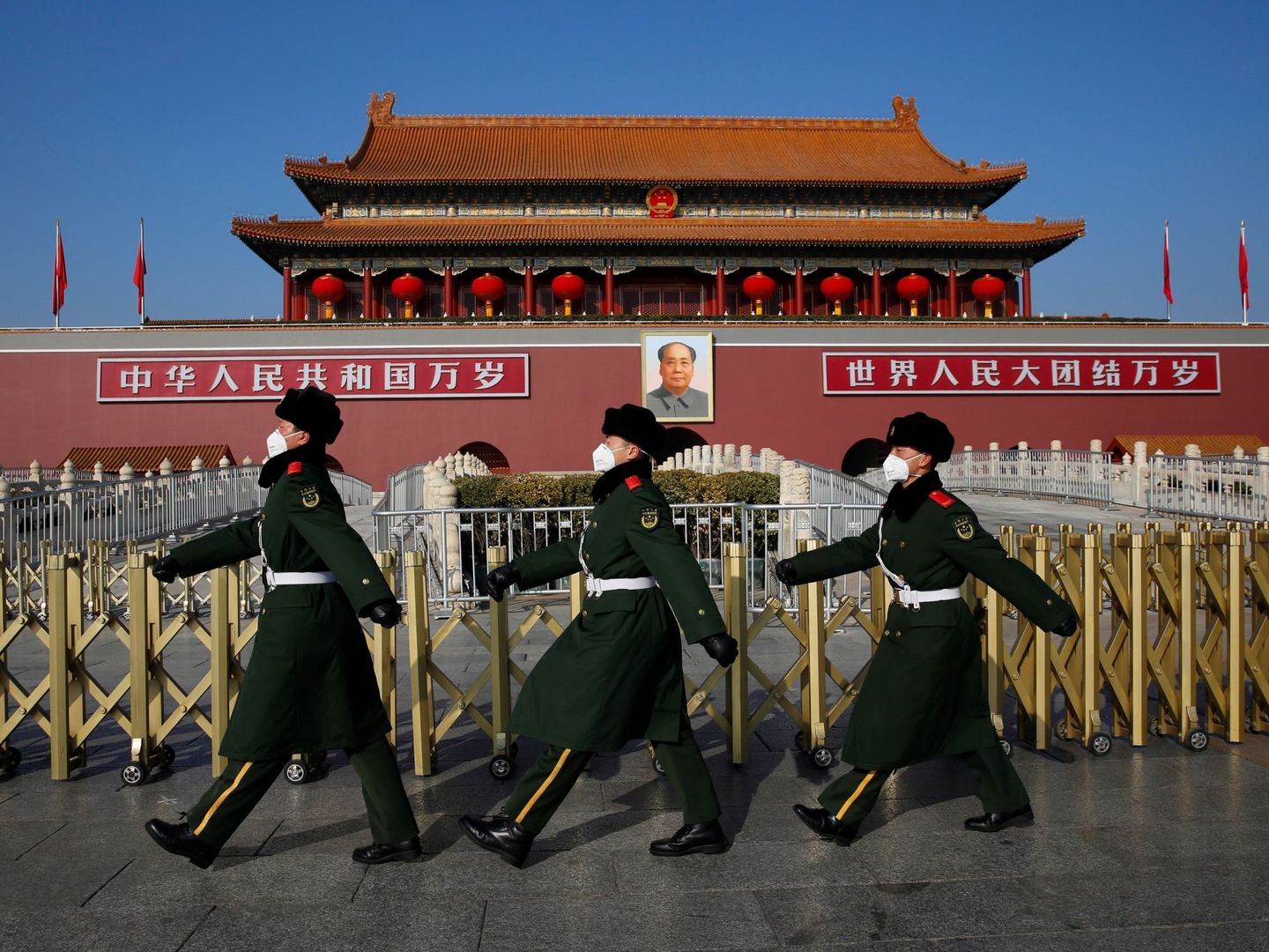 Tres policías chinos desfilan por la plaza de Tiananmen, en Pekín, ataviados con máscaras, el pasado 31 de enero. (EFE)