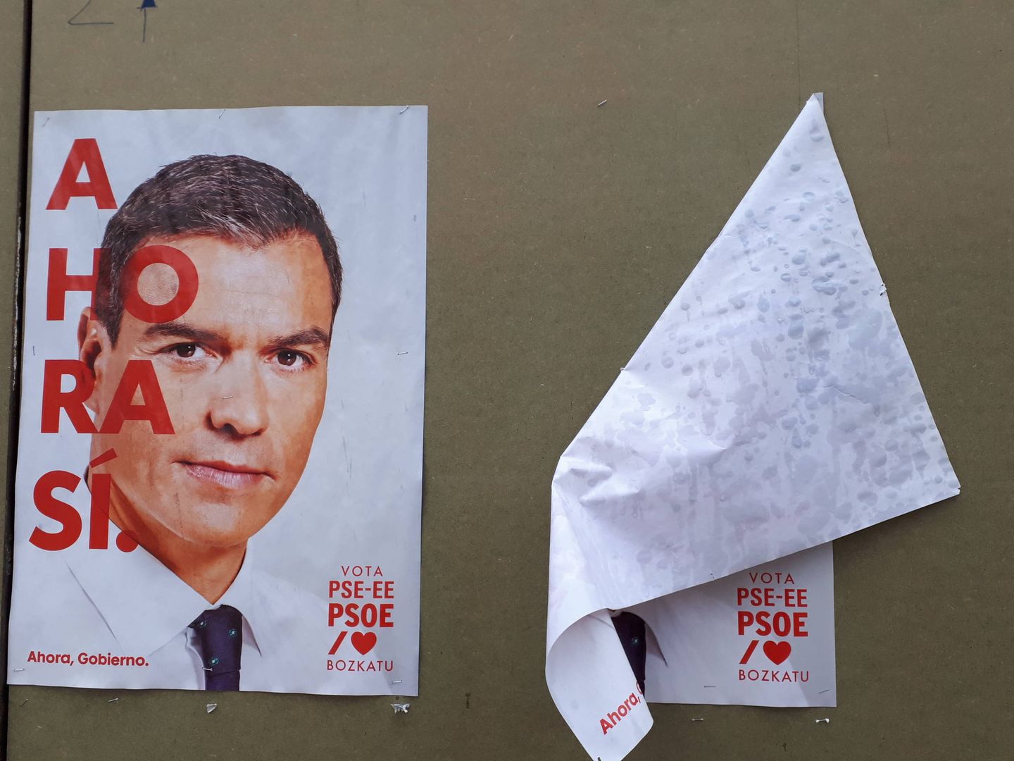 Los dos carteles del PSOE, uno de ellos doblado, en el tablón de propaganda electoral del centro de Labastida. (J. M. A.)
