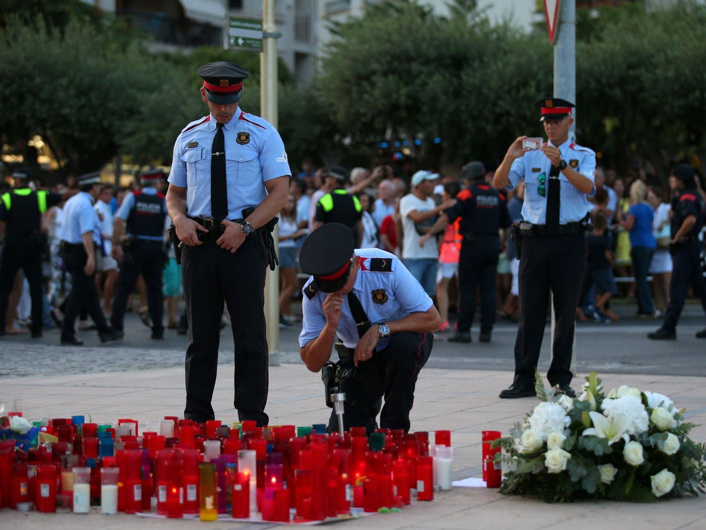 Mossos d'Esquadra encienden una vela en homenaje a las víctimas de los atentados. (Reuters)