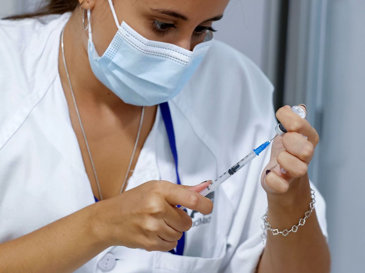 Foto: Una sanitaria prepara una dosis de una vacuna contra el covid-19 en el hospital Enfermera Isabel Zendal de Madrid. (EFE/ Chema Moya)