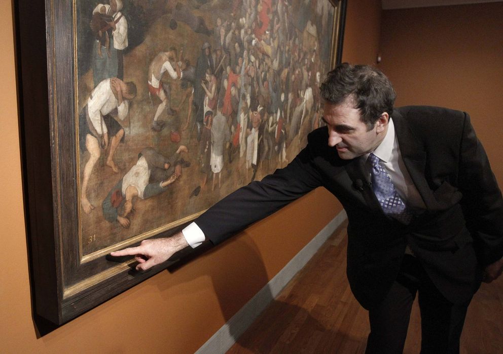 Foto: El director adjunto de Conservación e Investigación del Museo Nacional del Prado, Gabriele Finaldi, junto a 'El vino de la fiesta de San Martín', de Pieter Bruegel el Viejo, en diciembre de 2011. (EFE)