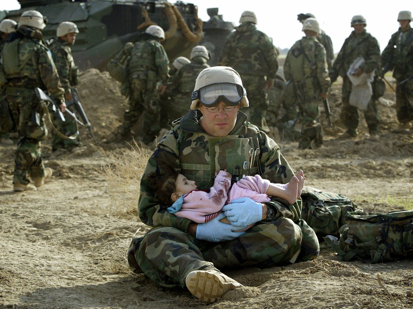 Un 'marine' estadounidense del cuerpo sanitario sostiene a un bebé iraquí durante la invasión, en marzo de 2003. (Reuters)