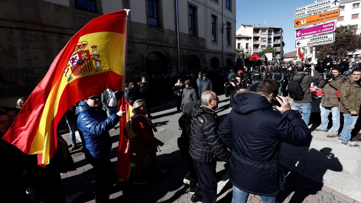 Varias personas se dirigen con banderas nacionales al acto de España Ciudadana en Alsasua entre el cordón policial. (EFE)