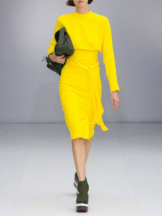 Vestido amarillo con zapatos caqui de Salvatore Ferragamo. (Imaxtree)