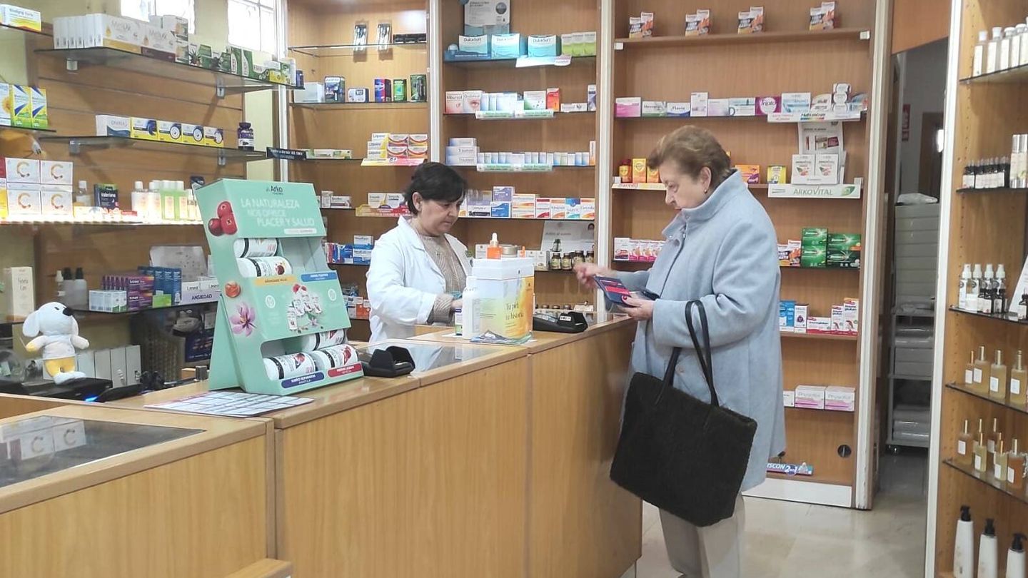 Eva atiende a una clienta en su farmacia de Aravaca. (L.B.)