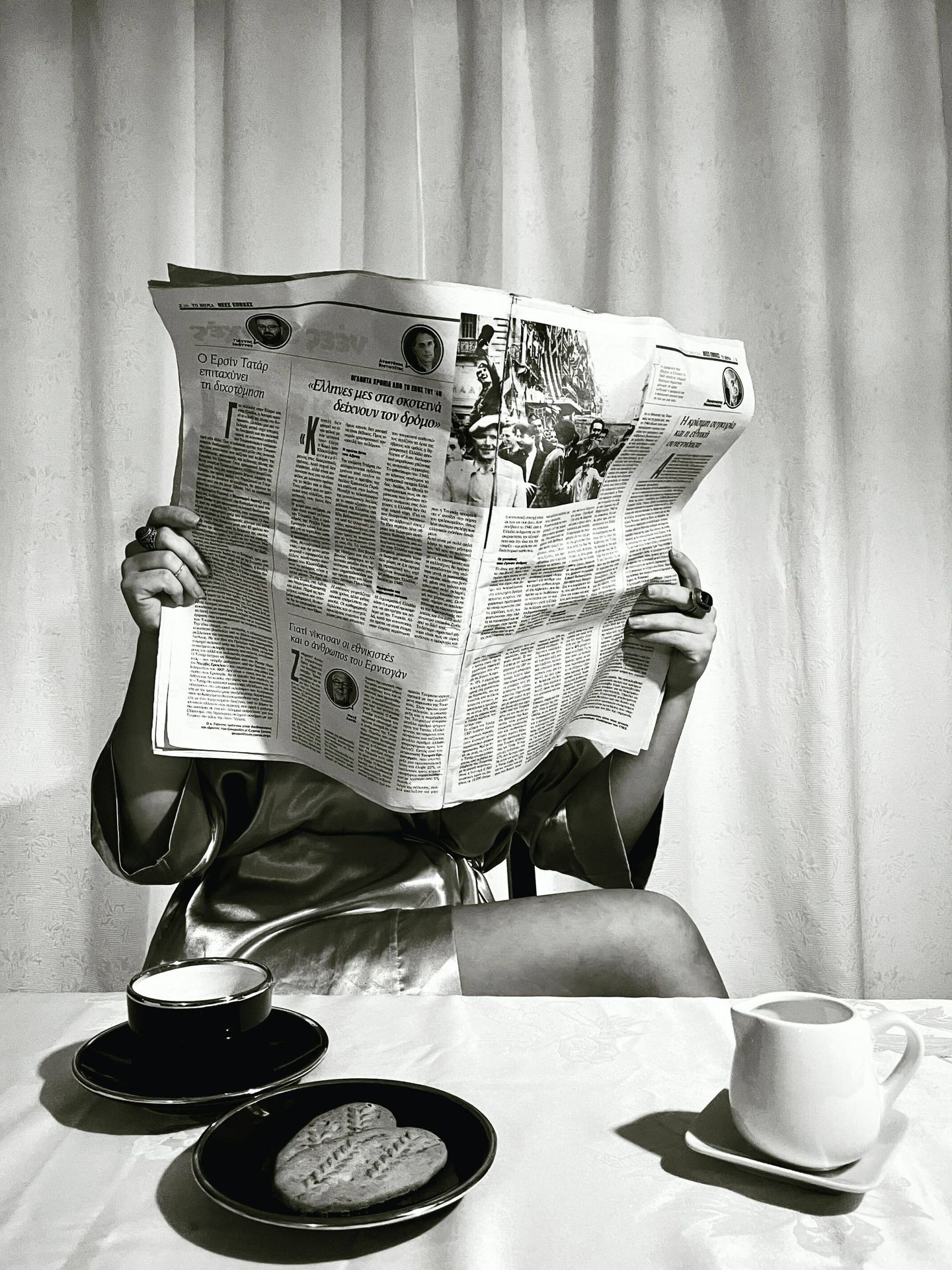 Mujer leyendo un periódico en papel durante el desayuno. (Unsplash)