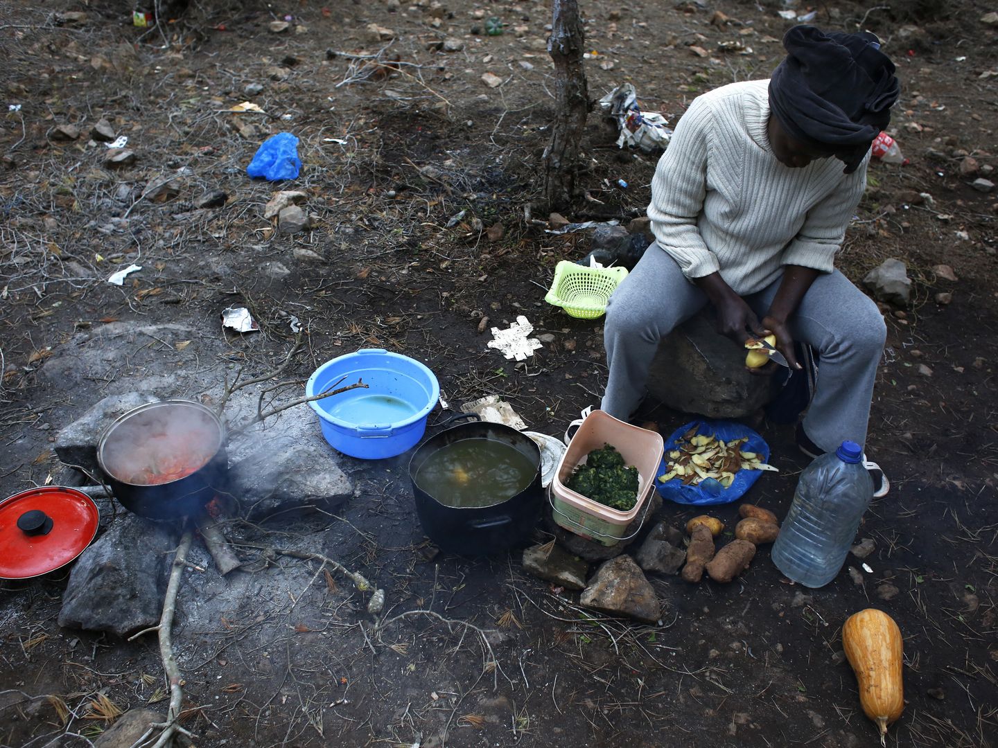 Rachel, una inmigrante de Camerún, cocina en el campamento clandestino de Bolingo, cerca de Melilla (Reuters).