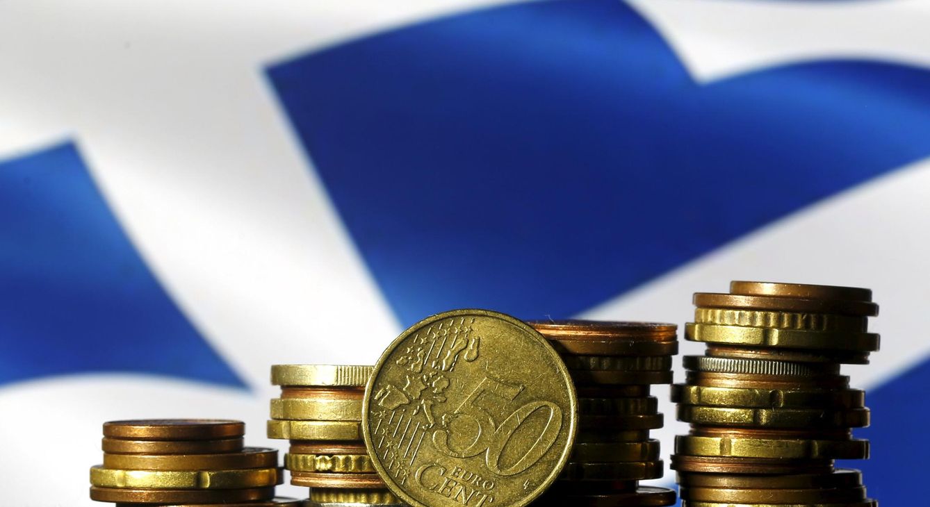 Monedas de euro con la bandera griega de fondo. (Reuters)