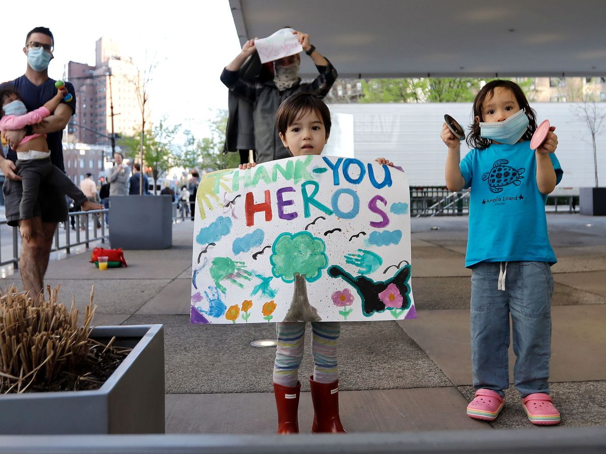 Foto: Unos niños aplauden a los trabajadores sanitarios en un hospital de Nueva York. (EFE)