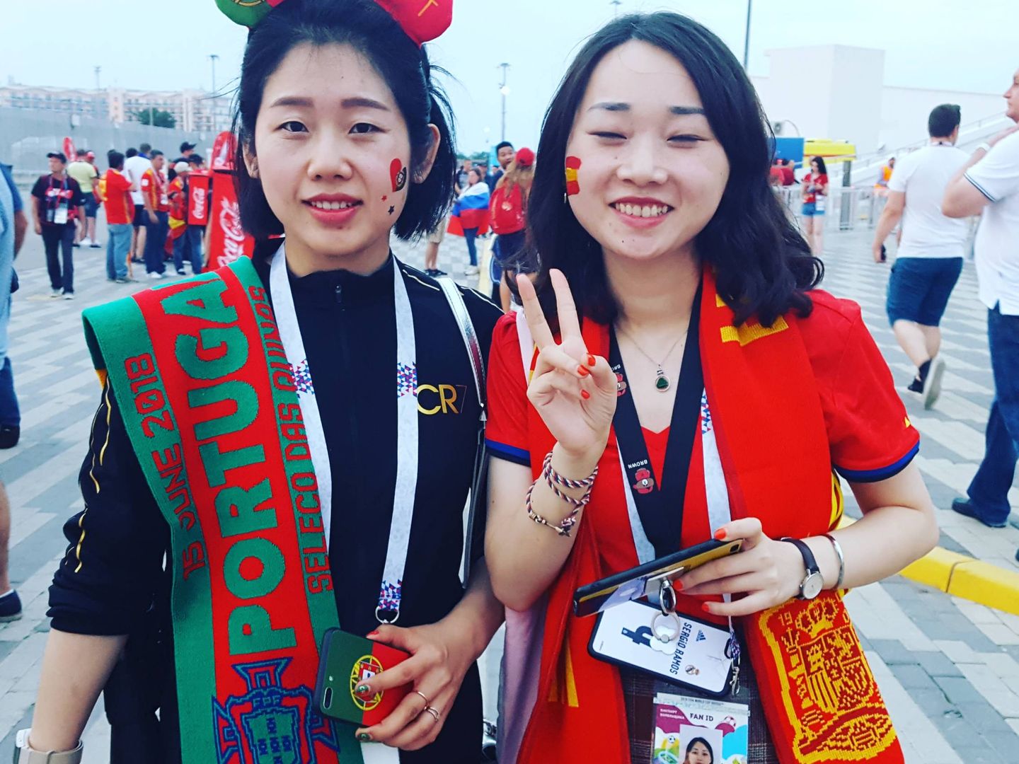 Dos aficionadas chinas en el partido de Sochi: una viene por Cristiano y la otra por Iniesta. (A. P.)
