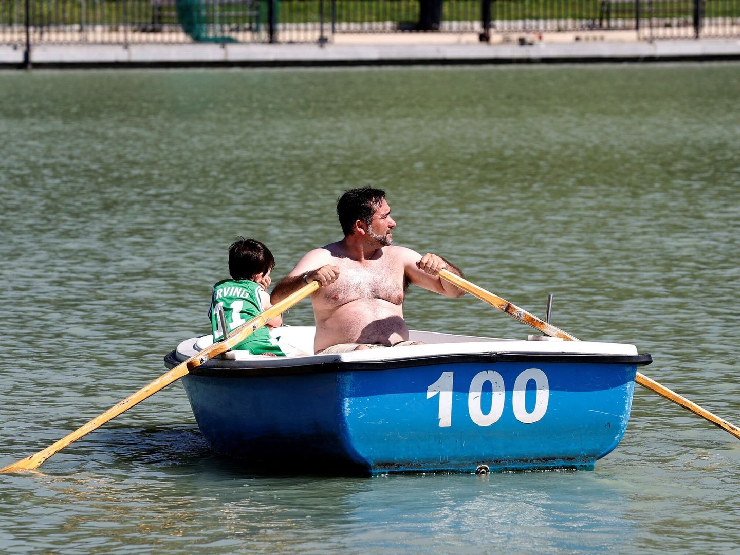 Un padre y un hijo disfrutan de un paseo en barca en el parque del Retiro. (EFE/Chema Moya)