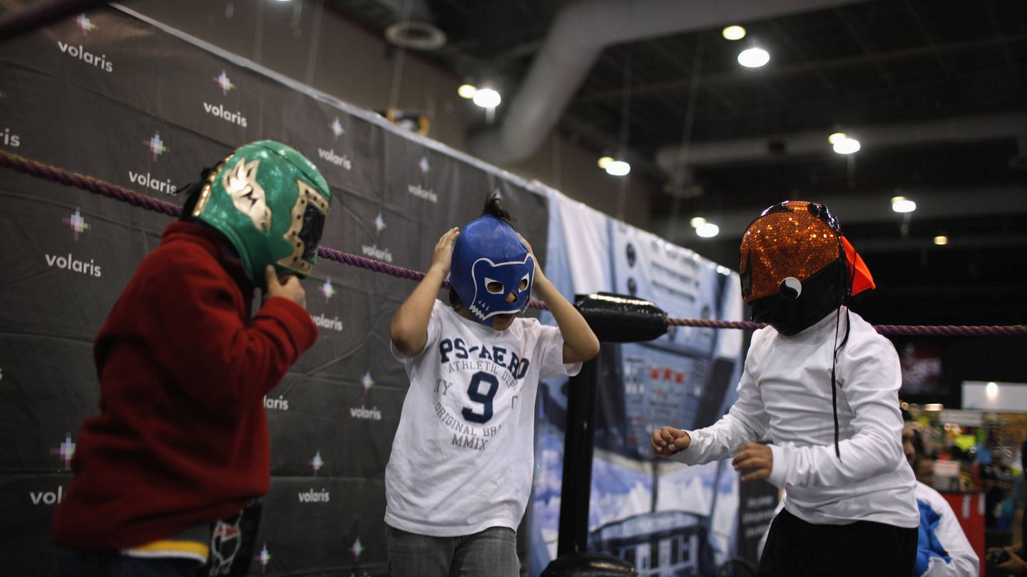 Unos niños se prueban máscaras de lucha libre durante una exposición sobre este deporte en Ciudad de México, en agosto de 2012. (Reuters)