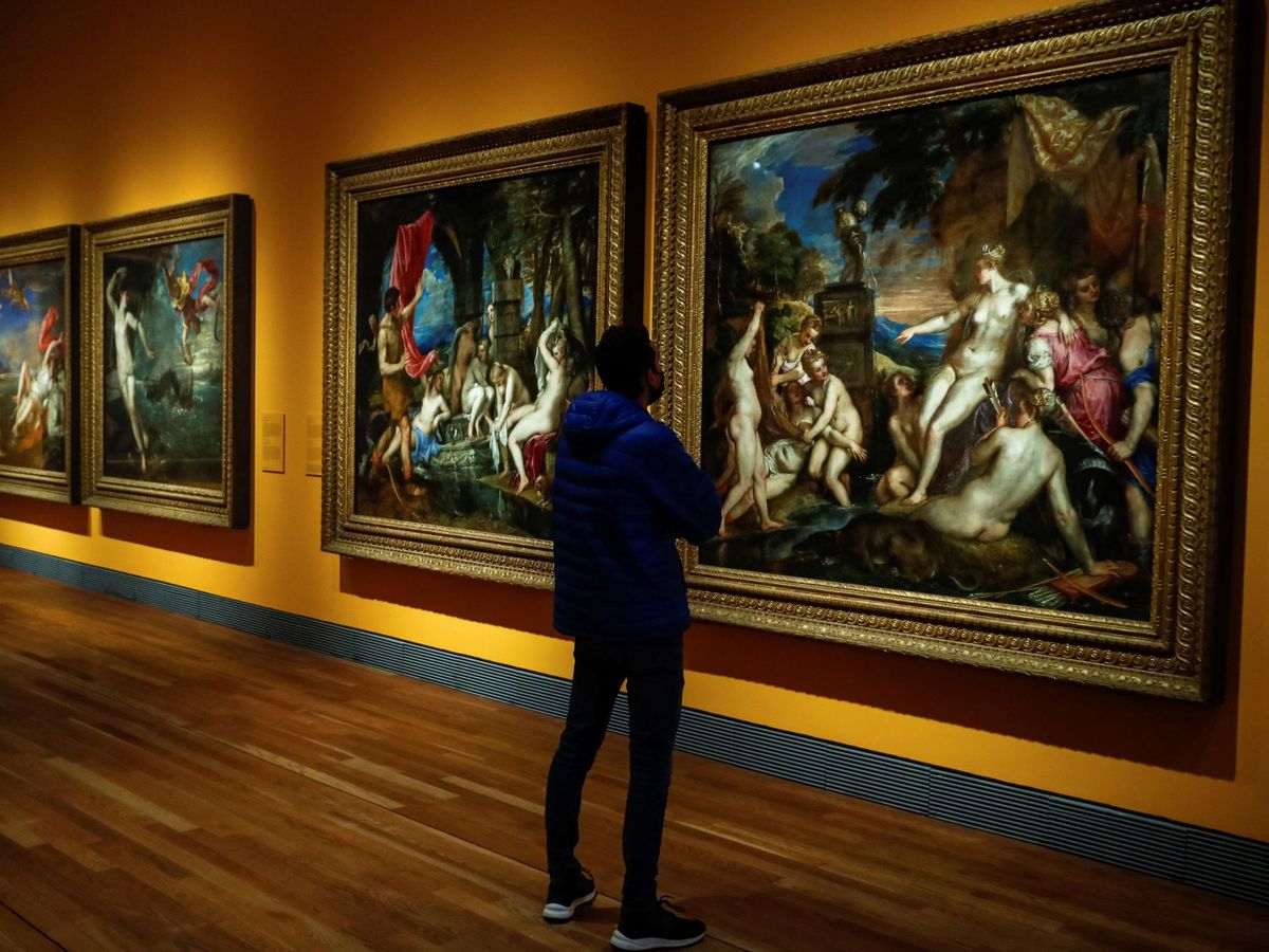 Foto: Un hombre observa la obra "Diana y Calisto" (dcha), (1556-1559), de Tiziano, durante la inauguración de la exposición “Pasiones Mitologicas” en el Museo del Prado en Madrid (EFE)