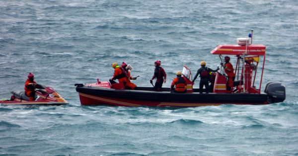 Foto: Un equipo subacuático del cuerpo de Bomberos de A Coruña retira del agua el cuerpo.