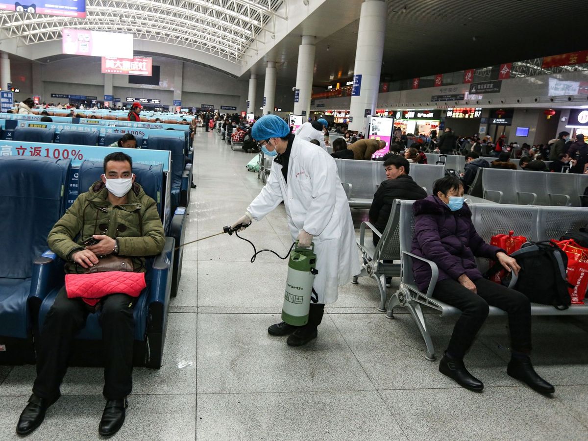 Foto: Operarios desinfectan una zona de espera de una estación en China. (EFE)
