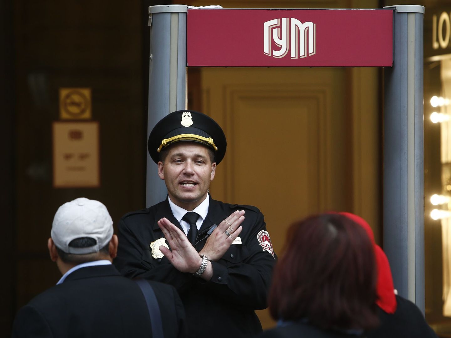 Un guardia de seguridad bloquea la entrada al centro comercial GUM por las amenazas de bomba, hoy en Moscú. (Reuters)