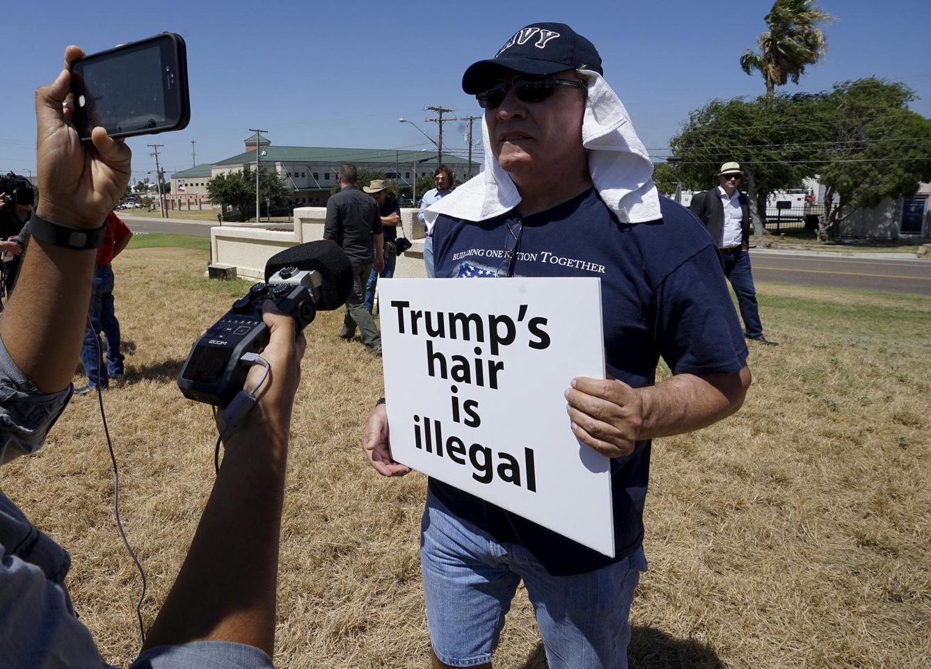 A protester is interviewed outside the airport as he awaits the arrival of republican presidential candidate donald trump, in laredo