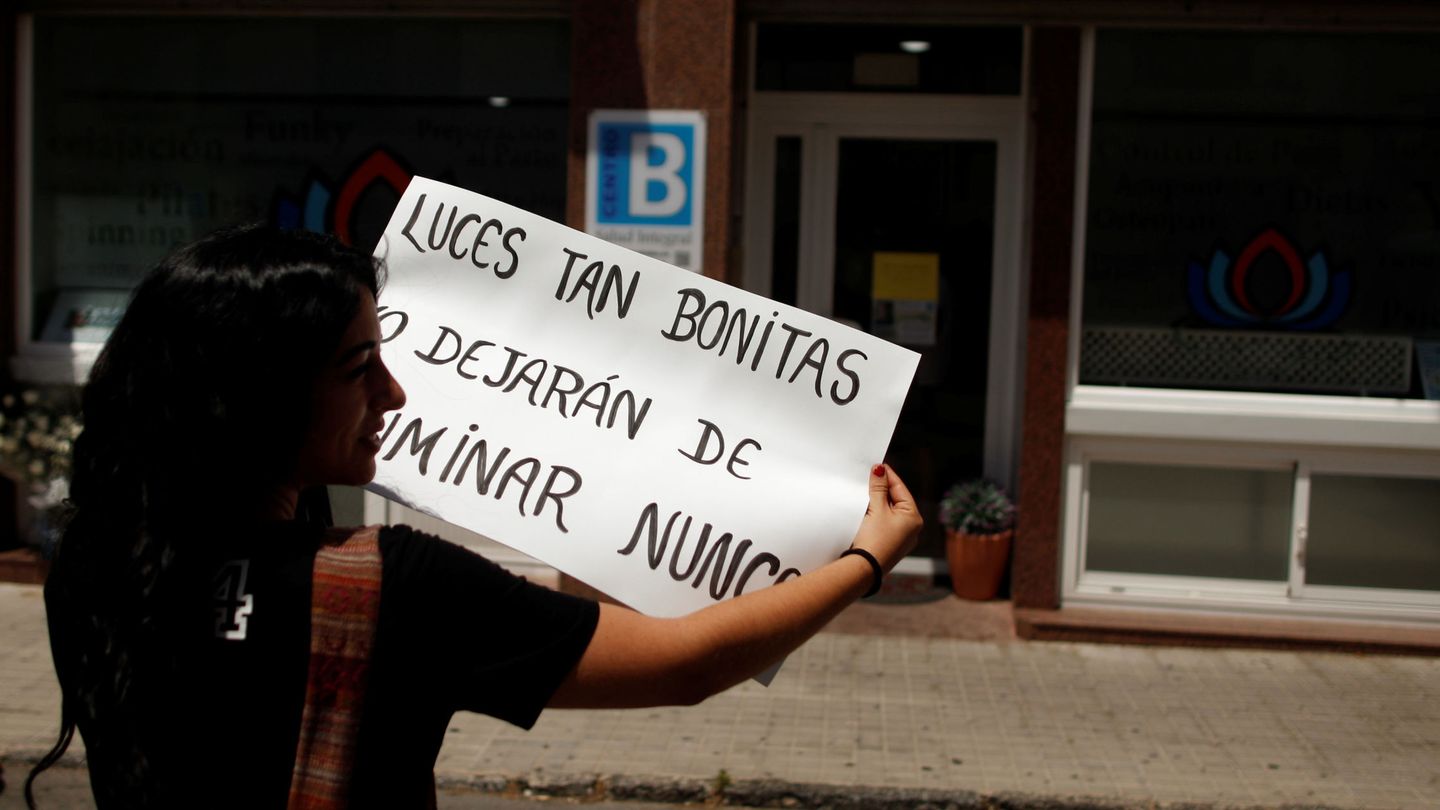 Una conocida de las víctimas con un cartel en su memoria, en Ronda. (Reuters)