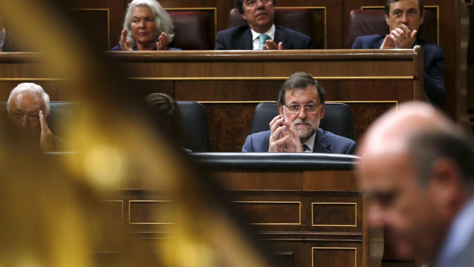 Foto: El presidente del Gobierno, Rajoy, al fondo mirando al ministro de Economía, Luis de Guindos. (Reuters)